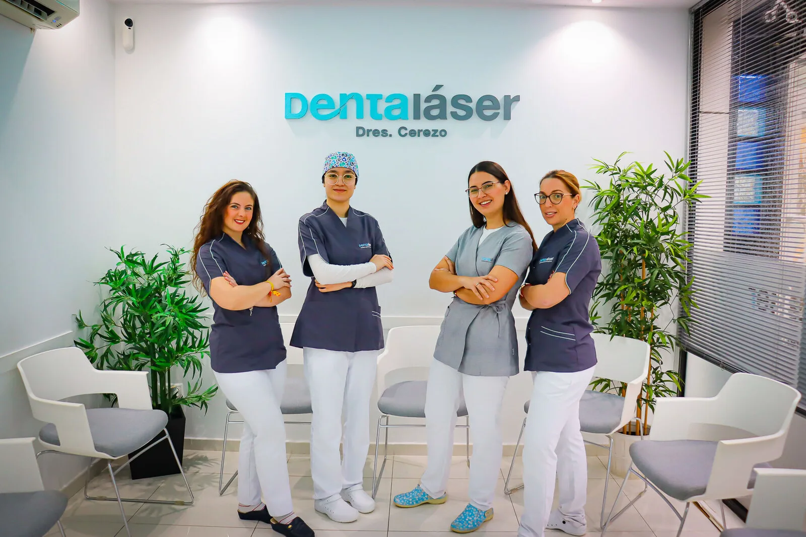 Equipo de recepción de Dentaláser Fuengirola, cuatro compañeras sonriendo junto al logo de la clínica