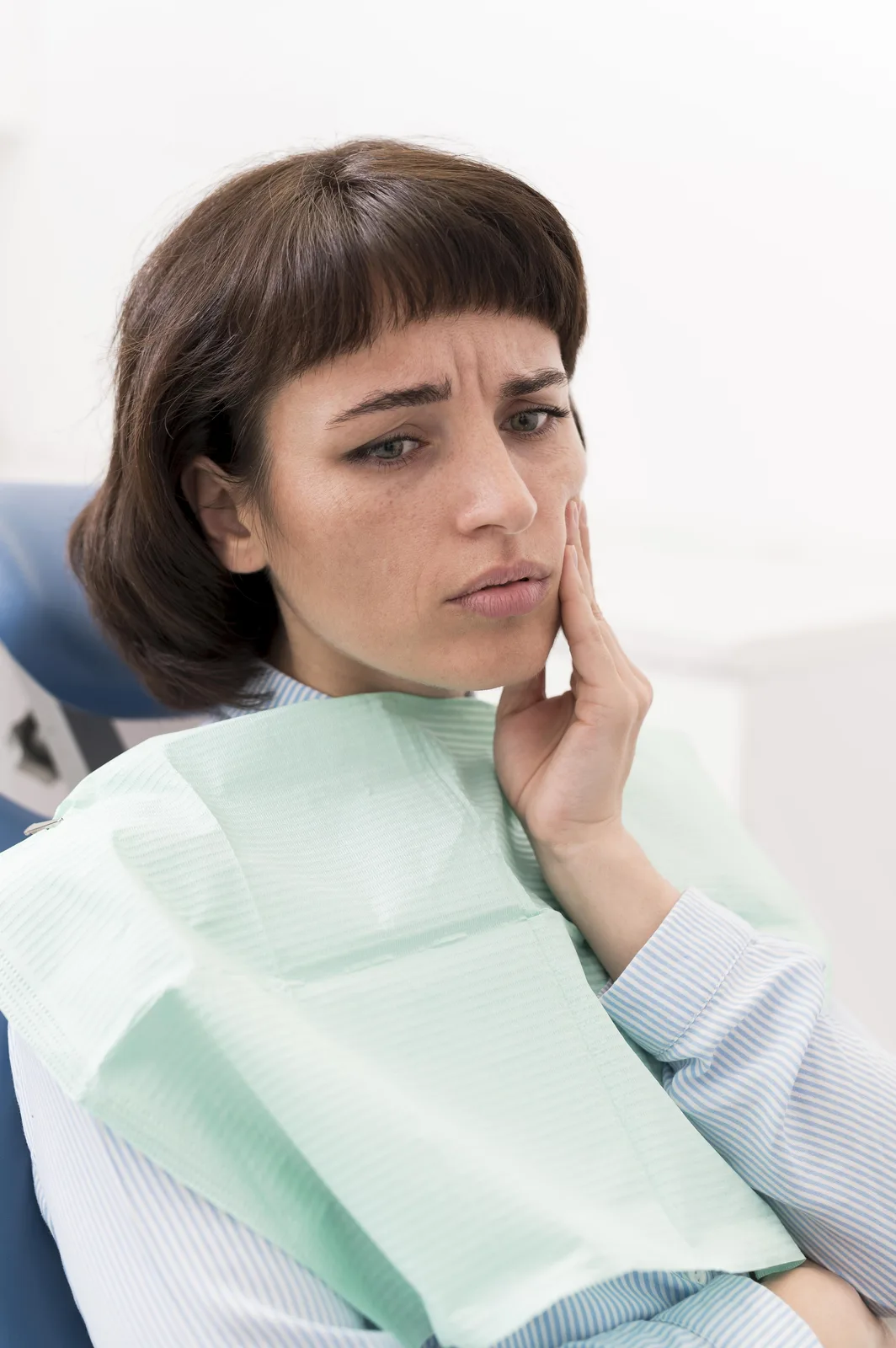 Paciente con dolor dental sujetándose la mejilla